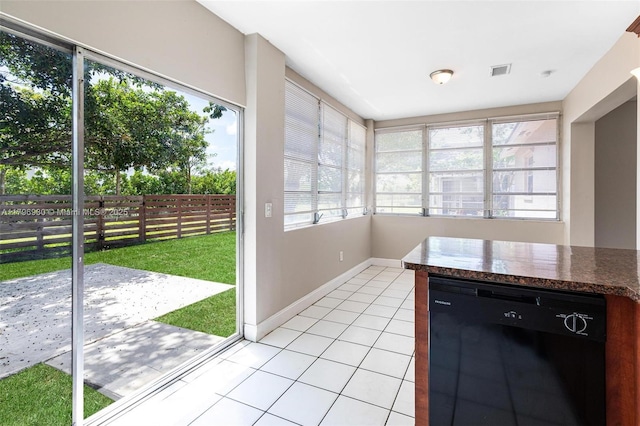 unfurnished sunroom featuring plenty of natural light, tile patterned flooring, and baseboards