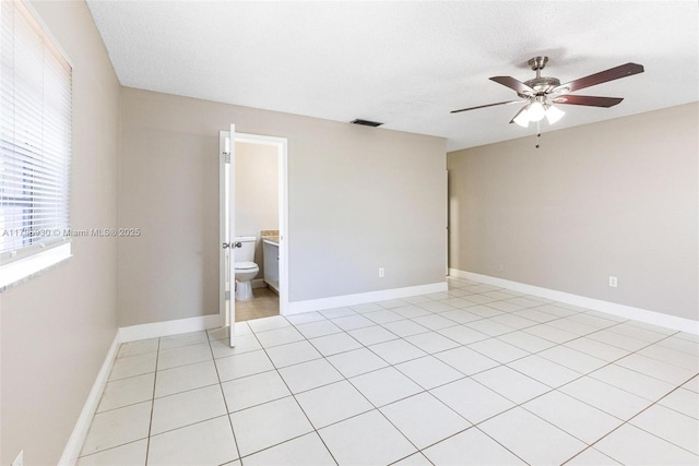 unfurnished room with ceiling fan and baseboards