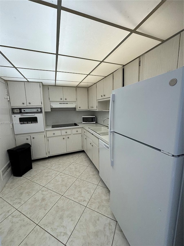 400 Kings Point Dr Unit 309, Sunny Isles Beach, FL 33160 - kitchen featuring white appliances, a sink, light tile patterned floors, light countertops, and under cabinet range hood