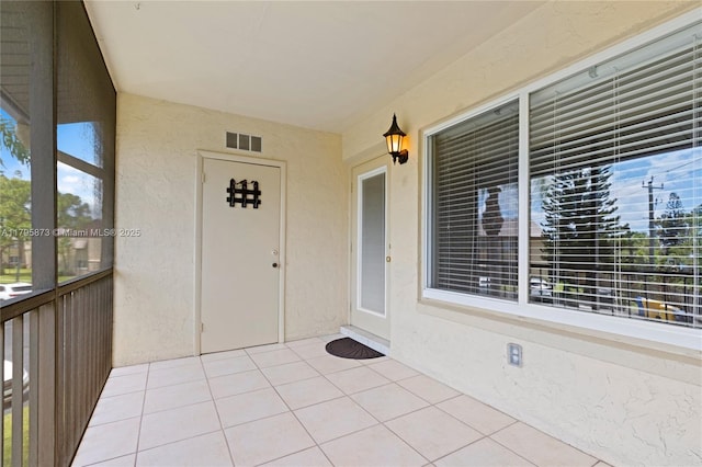 view of exterior entry with stucco siding and crawl space
