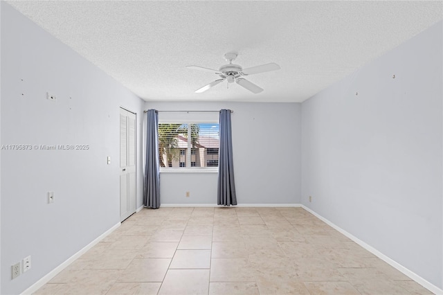 unfurnished room featuring a textured ceiling, ceiling fan, and baseboards