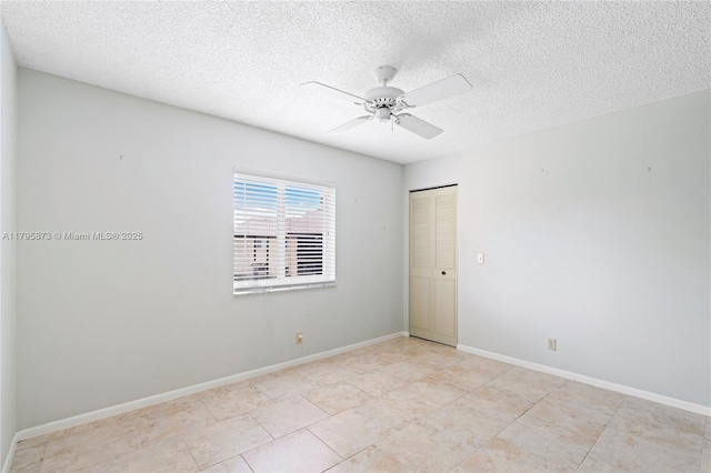 unfurnished room featuring a ceiling fan, a textured ceiling, light tile patterned floors, and baseboards
