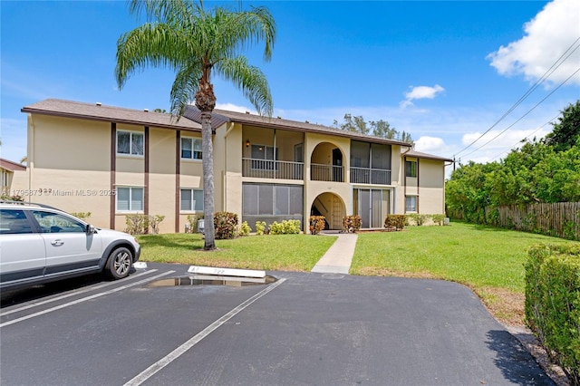 322 Pine Ridge Cir Unit A-2, Green Acres, FL 33463 - view of building exterior featuring uncovered parking and fence