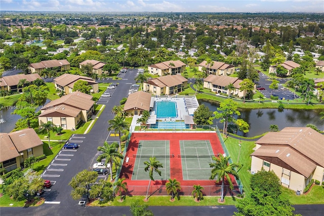 aerial view of residential area with a nearby body of water and a pool