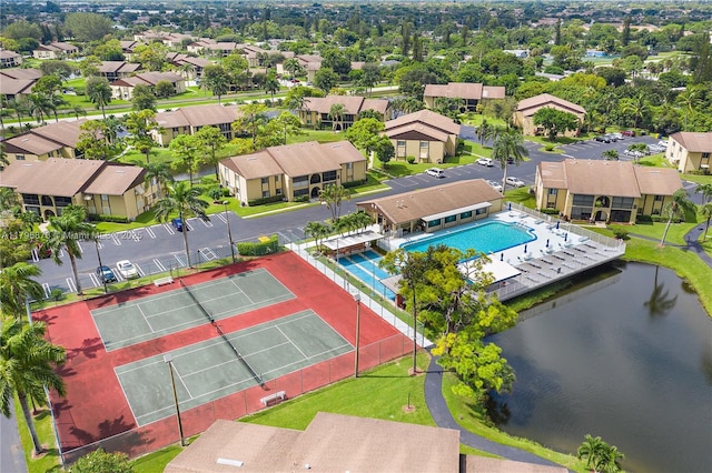 aerial view of residential area featuring a nearby body of water and a pool