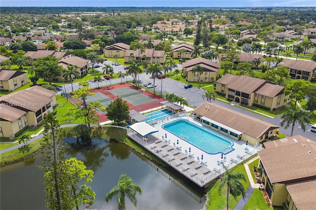 aerial view of residential area featuring a pool and a large body of water