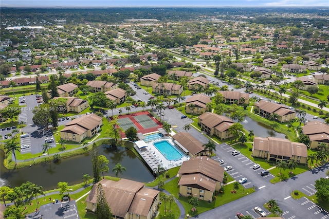 aerial perspective of suburban area with a pool area and a large body of water