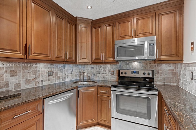 322 Pine Ridge Cir Unit A-2, Green Acres, FL 33463 - kitchen with stainless steel appliances, brown cabinets, dark stone counters, and a textured ceiling
