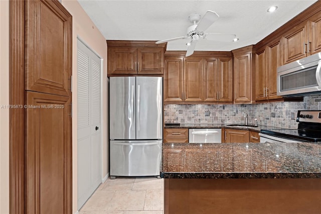 322 Pine Ridge Cir Unit A-2, Green Acres, FL 33463 - kitchen featuring appliances with stainless steel finishes, dark stone countertops, tasteful backsplash, and brown cabinetry