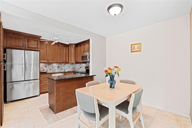 322 Pine Ridge Cir Unit A-2, Green Acres, FL 33463 - kitchen with appliances with stainless steel finishes, tasteful backsplash, a ceiling fan, a textured ceiling, and brown cabinetry