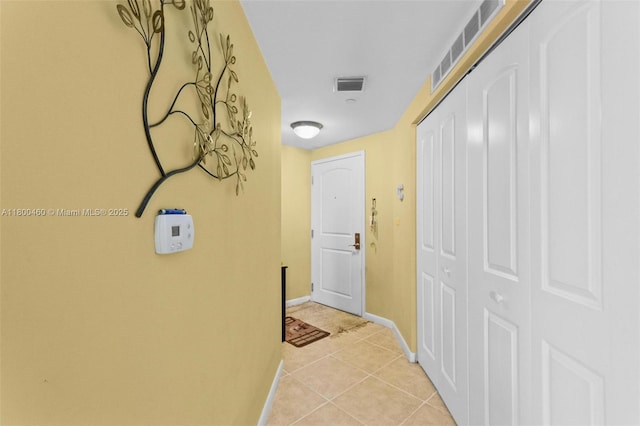 corridor with baseboards and light tile patterned floors