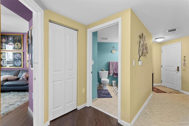 hallway featuring baseboards and light tile patterned flooring