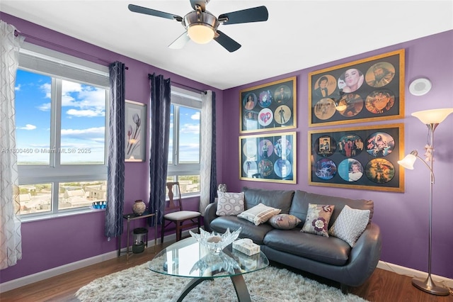 living room with ceiling fan, wood finished floors, and baseboards