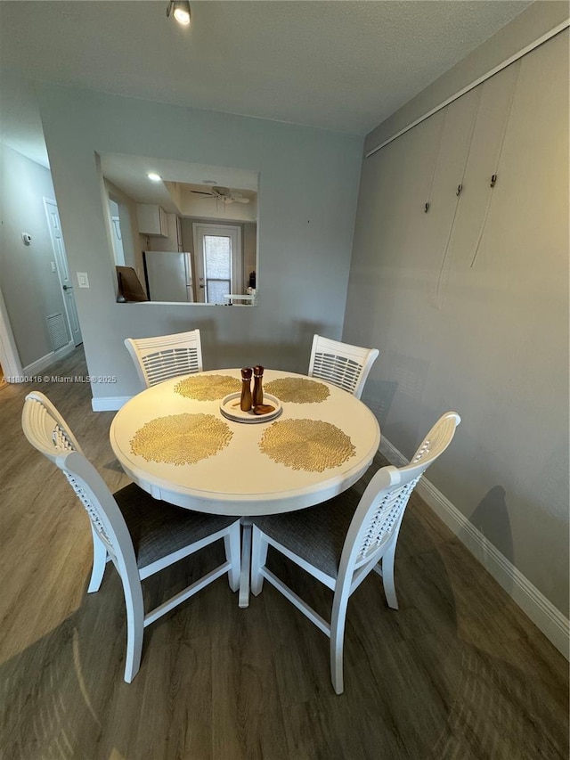 dining area featuring baseboards and wood finished floors