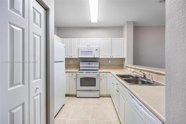 2933 SE 2nd St Unit 20, Homestead, FL 33033 - kitchen featuring white appliances, a sink, white cabinetry, light countertops, and light tile patterned floors