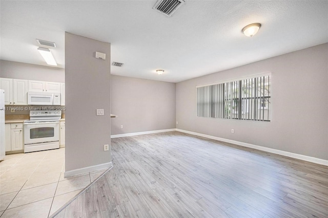 2933 SE 2nd St Unit 20, Homestead, FL 33033 - unfurnished living room featuring baseboards and light wood-style flooring