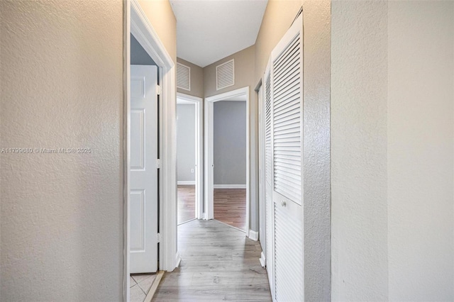 2933 SE 2nd St Unit 20, Homestead, FL 33033 - corridor with a textured wall, light wood finished floors, and baseboards