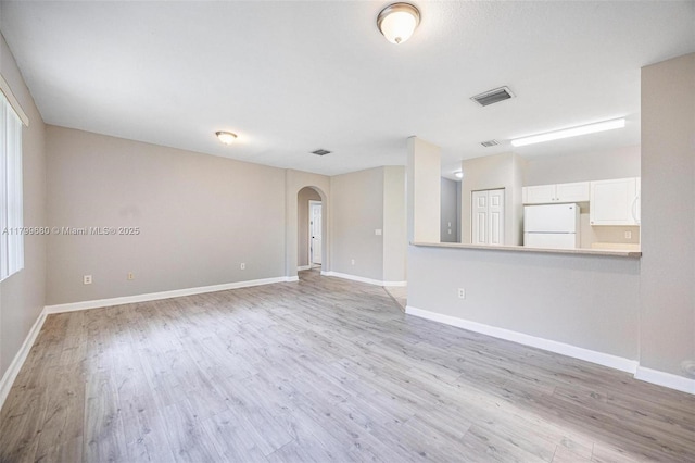 2933 SE 2nd St Unit 20, Homestead, FL 33033 - unfurnished living room with arched walkways, light wood finished floors, and baseboards