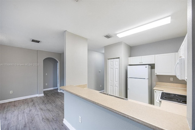 2933 SE 2nd St Unit 20, Homestead, FL 33033 - kitchen with white appliances, arched walkways, light wood finished floors, white cabinetry, and light countertops