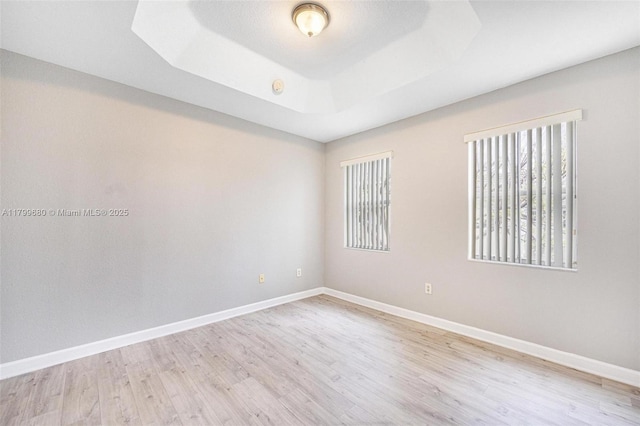 2933 SE 2nd St Unit 20, Homestead, FL 33033 - spare room with healthy amount of natural light, a tray ceiling, and light wood finished floors