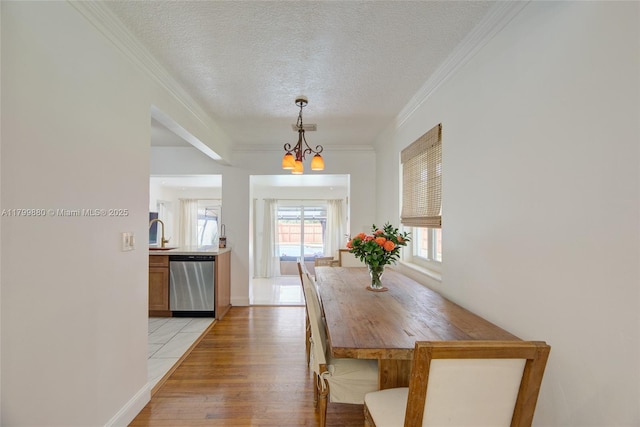 12000 NE 11th Ct, Biscayne Park, FL 33161 - dining room with a textured ceiling, a chandelier, light wood-type flooring, ornamental molding, and baseboards