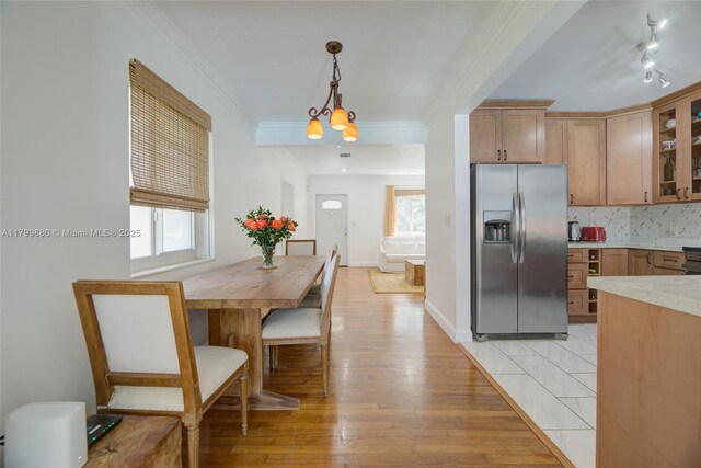 12000 NE 11th Ct, Biscayne Park, FL 33161 - kitchen with stainless steel fridge with ice dispenser, plenty of natural light, light countertops, glass insert cabinets, and ornamental molding
