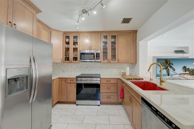 12000 NE 11th Ct, Biscayne Park, FL 33161 - kitchen featuring stainless steel appliances, a sink, light stone countertops, decorative backsplash, and glass insert cabinets