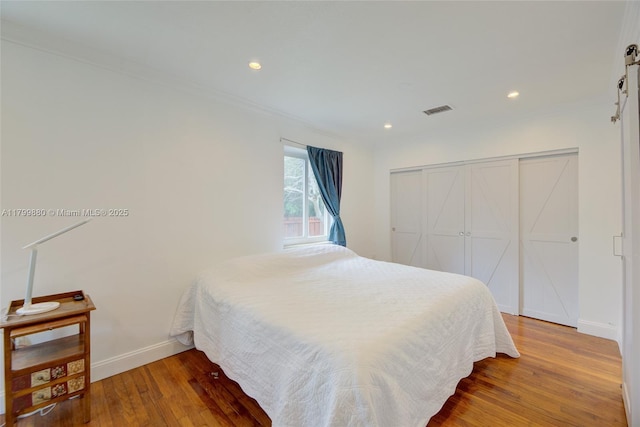 12000 NE 11th Ct, Biscayne Park, FL 33161 - bedroom featuring a barn door, crown molding, wood finished floors, baseboards, and recessed lighting