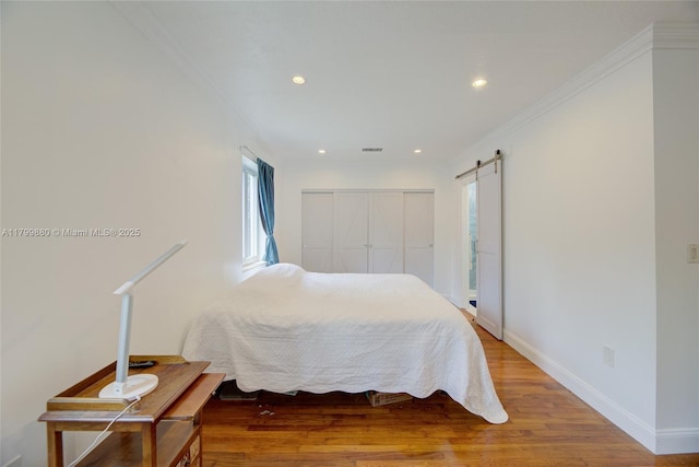 12000 NE 11th Ct, Biscayne Park, FL 33161 - bedroom featuring light wood-style floors, crown molding, recessed lighting, baseboards, and a barn door