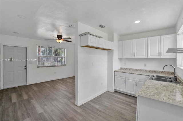 3051 NW 77th St, Miami, FL 33147 - kitchen with a sink, white cabinets, a ceiling fan, light wood-type flooring, and baseboards
