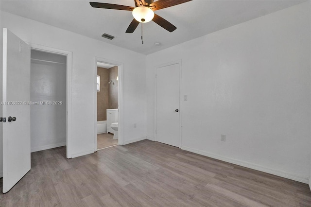 3051 NW 77th St, Miami, FL 33147 - unfurnished bedroom featuring wood finished floors, baseboards, connected bathroom, and a ceiling fan