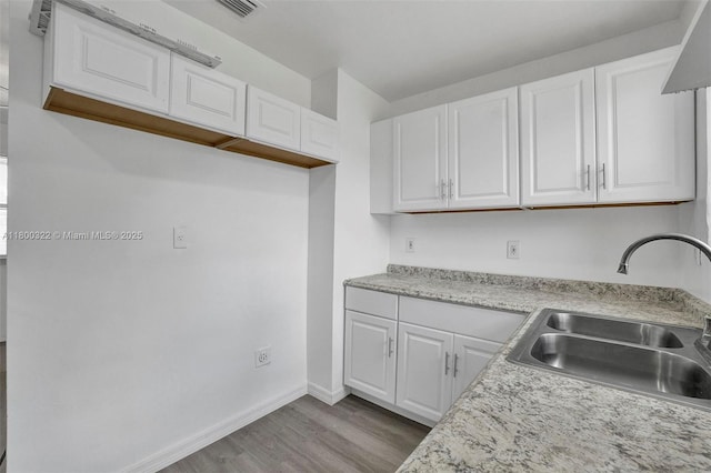 3051 NW 77th St, Miami, FL 33147 - kitchen featuring a sink, white cabinets, dark wood-type flooring, and light countertops