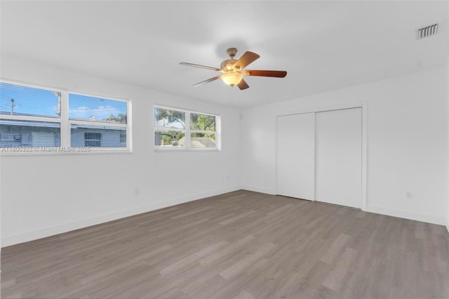 3051 NW 77th St, Miami, FL 33147 - unfurnished bedroom with wood finished floors, a closet, a ceiling fan, and baseboards