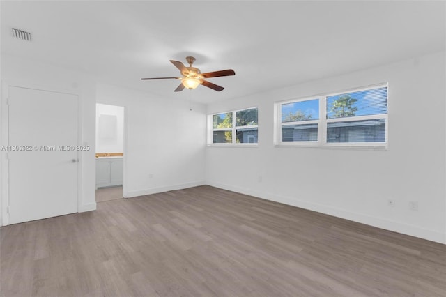 3051 NW 77th St, Miami, FL 33147 - unfurnished bedroom featuring wood finished floors, baseboards, and a ceiling fan