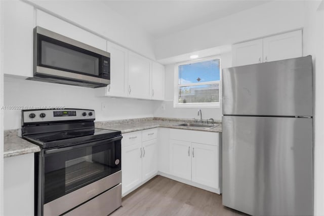 3051 NW 77th St, Miami, FL 33147 - kitchen with appliances with stainless steel finishes, a sink, and white cabinets