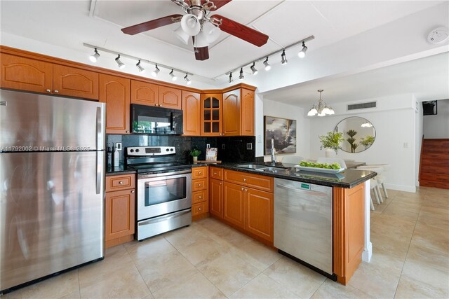 4730 SW 67th Ave Unit I1, Miami, FL 33155 - kitchen with stainless steel appliances, a sink, track lighting, a peninsula, and brown cabinets