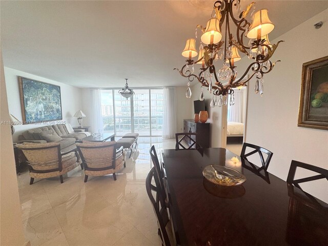 dining area featuring a chandelier and a wall of windows