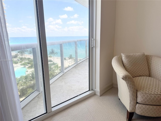 living area with a water view, carpet floors, and baseboards