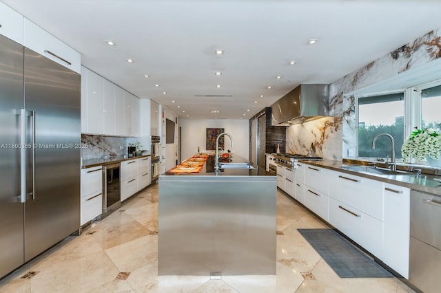 418 Tammarind Dr, Hallandale Beach, FL 33009 - kitchen with appliances with stainless steel finishes, modern cabinets, beverage cooler, a sink, and decorative backsplash