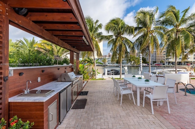 418 Tammarind Dr, Hallandale Beach, FL 33009 - view of patio with area for grilling, an outdoor kitchen, a water view, a sink, and outdoor dining space