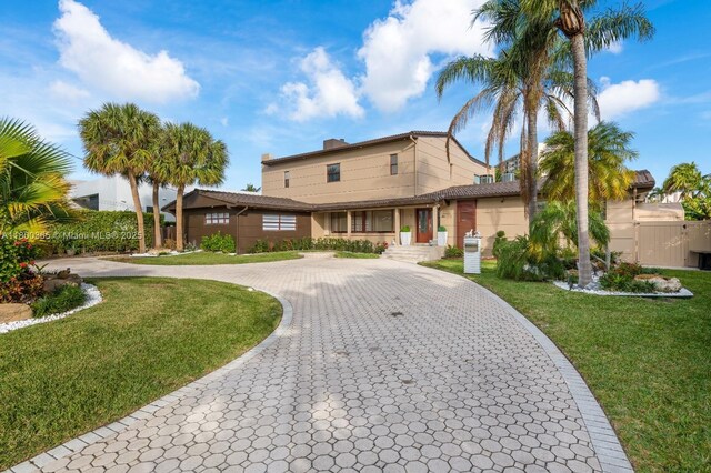418 Tammarind Dr, Hallandale Beach, FL 33009 - view of front of property with curved driveway, a front yard, and a gate