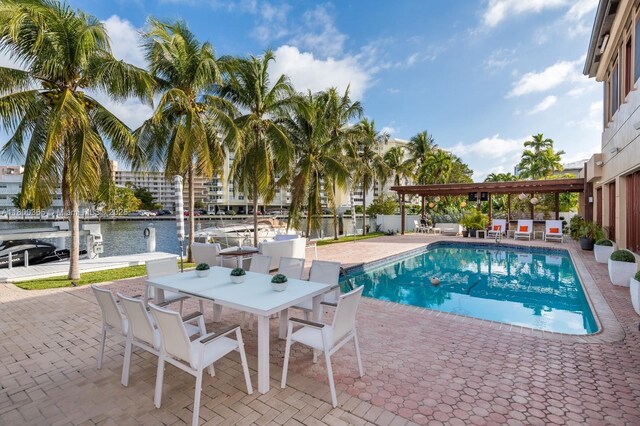 418 Tammarind Dr, Hallandale Beach, FL 33009 - view of pool with a patio, a water view, outdoor dining space, and fence