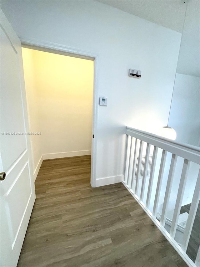 hall featuring wood finished floors and baseboards