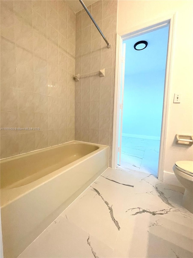 bathroom with marble finish flooring, toilet, and shower / bath combination