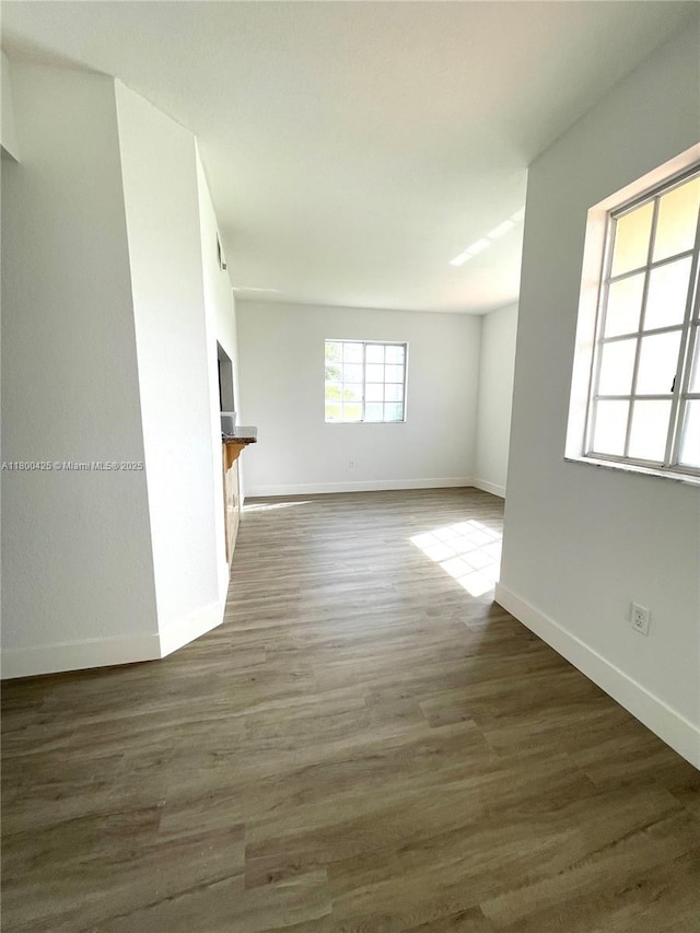 unfurnished living room with baseboards and wood finished floors