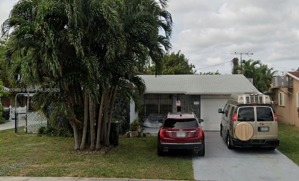 328 SE 2nd Ave, Dania Beach, FL 33004 - view of front of home with an attached garage, driveway, and a front yard