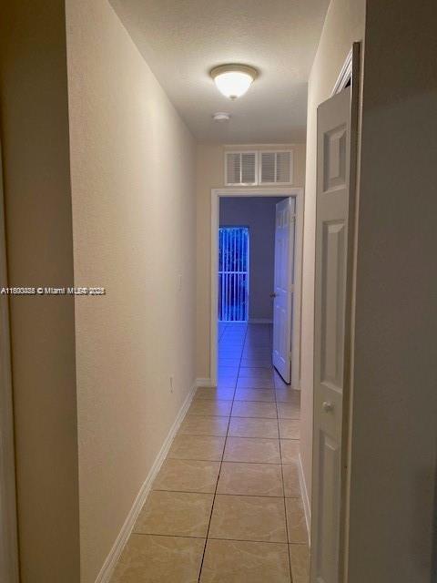 646 SW 7th Ter, Florida City, FL 33034 - corridor with light tile patterned floors and baseboards