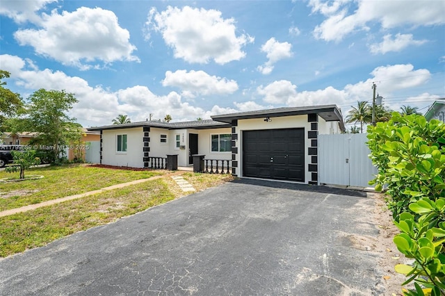 7450 Branch St, Hollywood, FL 33024 - single story home featuring a garage, stucco siding, driveway, fence, and a gate
