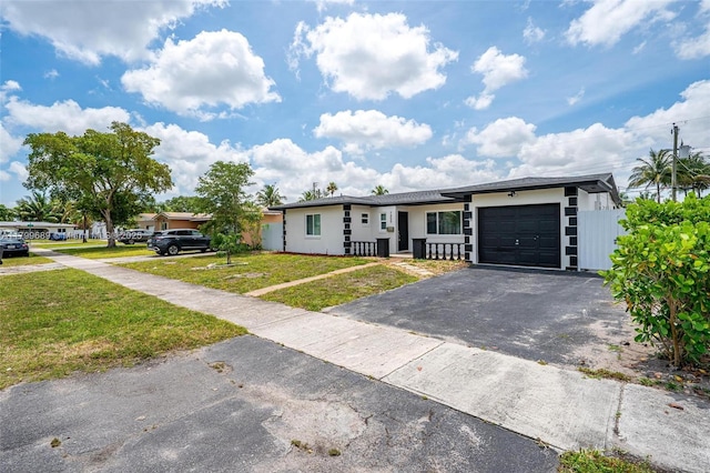 7450 Branch St, Hollywood, FL 33024 - view of front of house with asphalt driveway, an attached garage, and stucco siding