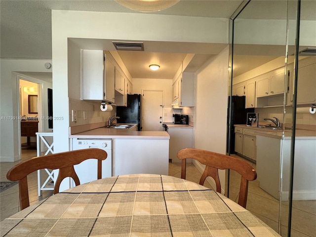 kitchen featuring a sink, tasteful backsplash, and tile patterned floors